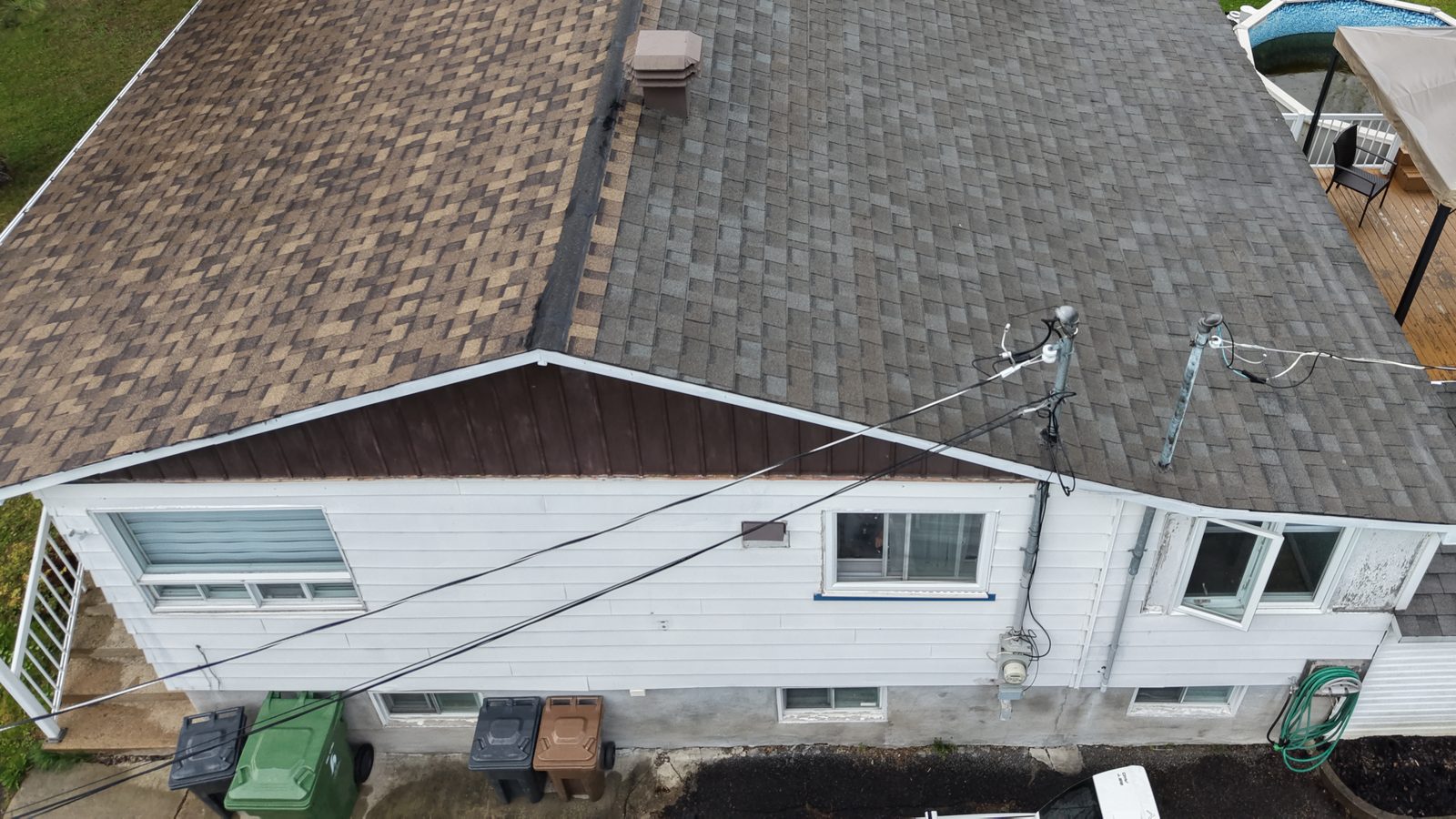 Toiture en bardeaux d'asphalte d'un bungalow avec évents et mât électrique, photographiée par drone lors d'une inspection