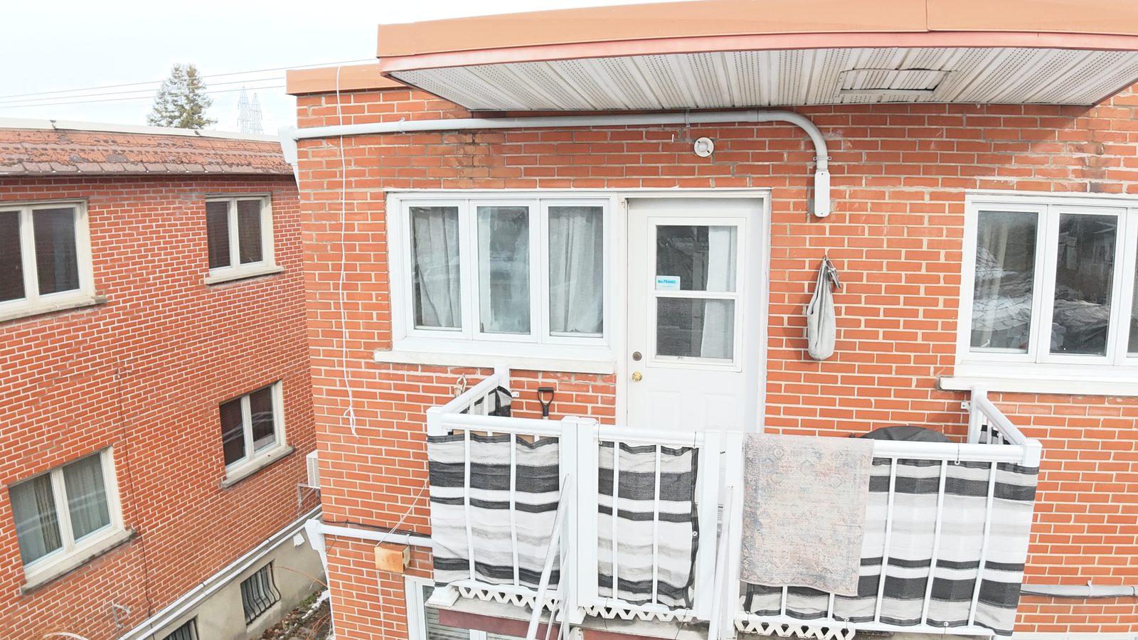 Rear of a brick plex with balconies and a back door